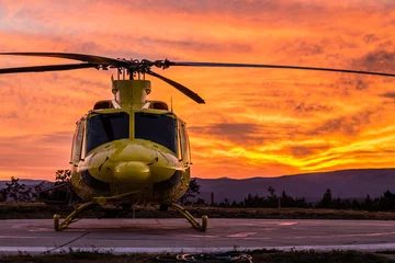 Zelfklevend Fotobehang Helikopter op een zonsondergang © Javier