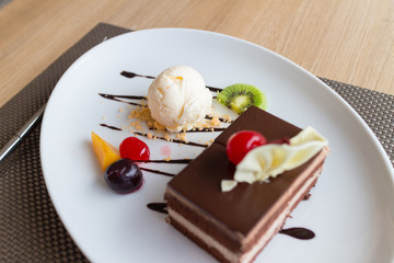 chocolate layer cake and vanilla ice cream with fresh fruit and cherry