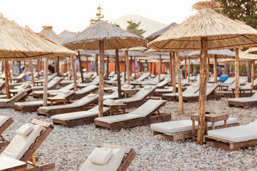 sunbeds and straw umbrellas on beach