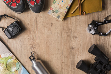 Overhead view of travel equipment for an adventure trip on wooden floor with copy space. Adventure travel concept.