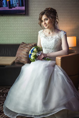 woman with wedding bouquet sitting on chair