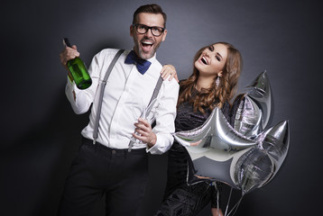 Cheerful couple with champagne celebrating new year