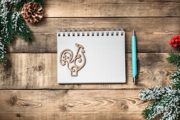 Blank paper notebook on brown wooden table background. Top view with copy space.