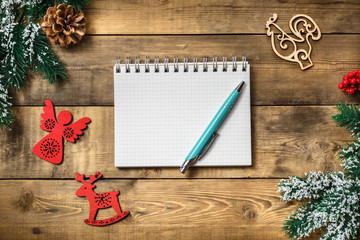 Blank paper notebook on brown wooden table background. Top view with copy space.