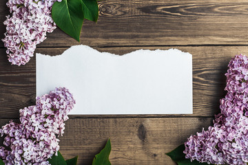 A wooden background of brown with lilac and a clean sheet of paper.