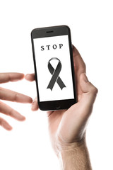 Hand holding smartphone, blank screen with black ribbon isolated on white background. World Cancer Day. Melanoma concept