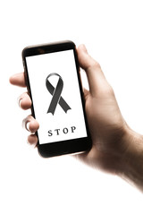 Hand holding smartphone, blank screen with black ribbon isolated on white background. World Cancer Day. Melanoma concept