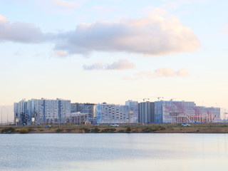Fototapeta premium panorama of city blocks of tall buildings on the beach at sunset