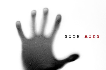 concept AIDS, under the hand of a white cloth with words Stop AIDS, HIV