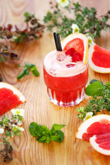 Red summer tasty cocktail with grapefruit on wooden table 