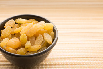 Healthy diet food white raisins full of natural vitamins in cup on bright light background