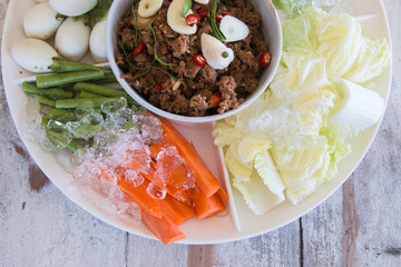 Thailand food Spicy Mince Pork with Chili Paste with fresh vegetables. on wooden table background.