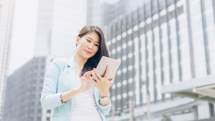 Obraz premium lifestyle business woman feel happy using smartphone, urban city background , business concept