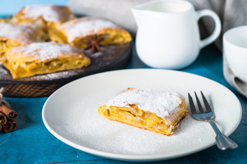 Apple strudel pie. Puff pastry on blue.