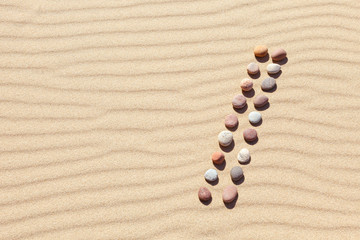 Pattern of colored pebbles on clean sand. Zen background, harmony and meditation concept