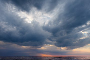 Naklejka na ściany i meble Dark, grey storm clouds above the sea.