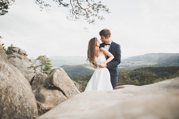 Beautiful wedding couple, bride and groom, in love on the background of mountains