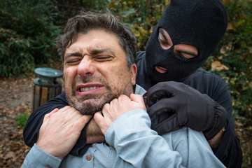 Burglar fighting with man outdoors at night