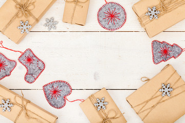 frame made of homemade wrapped christmas and new year present boxes and decoration on wooden background with copy space for text. holiday and celebration concept. above view, flat lay.