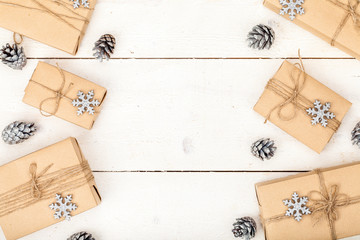 frame made of homemade wrapped christmas and new year present boxes and decoration on wooden background with copy space for text. holiday and celebration concept. above view, flat lay.
