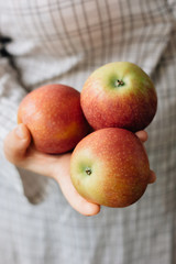 Three fresh apples in a woman hands.