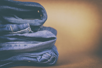 Women's jeans folded in a pile on a colored background. Made in a vintage performance.
