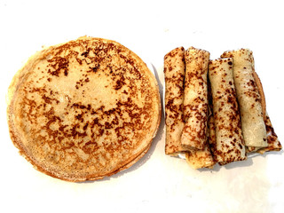Russian flat pancake of thin batter fried on both sides of a griddle
