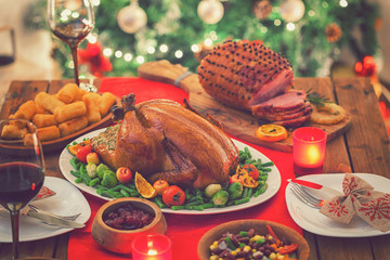 Stuffed Christmas turkey dinner served in front of a Christmas tree 