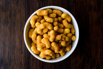Peanut Chips on dark wooden surface.