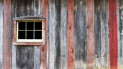 Obraz na płótnie Canvas background of a barn wall with multicolored wooden boards and a window