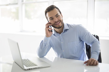 mexican attractive businessman on his 30s working at modern home office with computer laptop