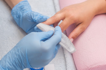 The master prepares the nails for manicure