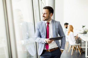 Fototapeta premium Young businessman with digital tablet in office