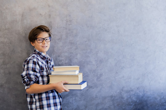 Cute teenage school boy holding books