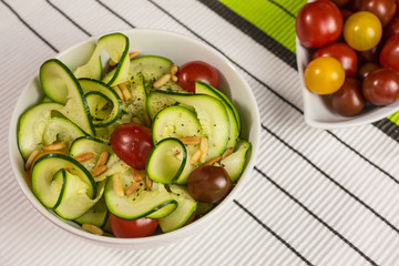 spiralized  vegetarian zucchini noodles with  yellow, red and dark red tomatoes