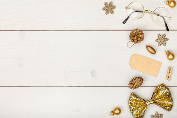 christmas or new year frame composition. christmas decorations in gold colors on wooden background with empty copy space for text. holiday and celebration concept for postcard or invitation. top view