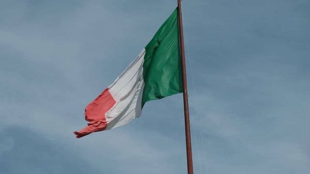 Italian flag fluttering against blue sky