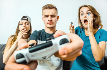 Gripped teens friends having fun playing a video game competition, stress emotion