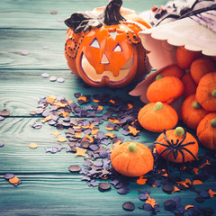 Halloween trick or treat still life on dark green. Toy pumpkin, sweets, marshmalllow, confetti....