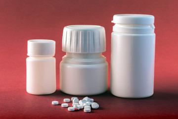 Pills boats white with white tablets of different types isolated on red background