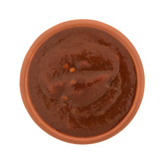 Top view of a small bowl of adobo sauce isolated on a white background.