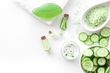 Fresh organic cosmetics with cucumber. Cream, lotion, spa salt on white background top view copyspace