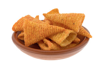 A small red clay bowl filled with cheese flavored cone shaped corn chips isolated on a white background.