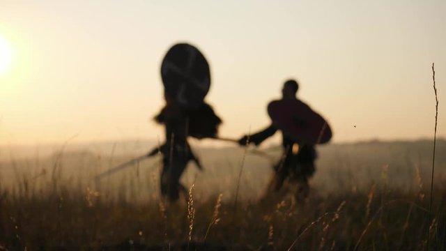 Silhouettes of warriors Viking are fighting with swords and shields. Contre-jour