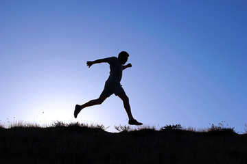 Running man silhouette at sunset