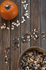 Pumpkin, nuts and dried fruits on a rustic wooden background. Top view, background
