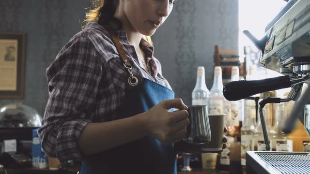 Female barista making fresh coffee on machine 