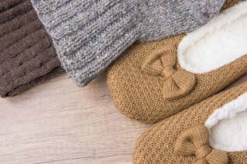 Handmade Warm Knitted Socks From Coarse Wool Yarn Fluffy Fur Slippers on Wood Background. Winter Autumn Eco Fashion Kinfolk Style. Natural Materials.