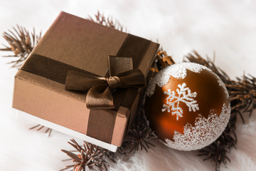 Fototapeta na wymiar Christmas gift and Christmas ball in chocolate tones. Close-up.