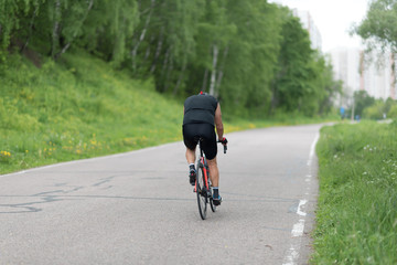 a road bike with a cyclist pedaling on a road.